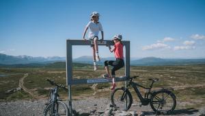 Eine Frau, die auf einem Spiegel neben zwei Fahrrädern sitzt. in der Unterkunft Oset Fjellhotell in Gol