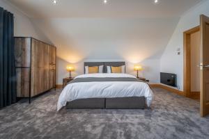 een slaapkamer met een groot bed en 2 lampen bij The Hoose at The Vu in Bathgate