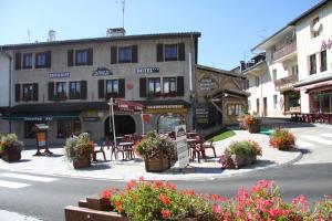 ein Gebäude mit Tischen und Stühlen auf einer Straße in der Unterkunft Hôtel Restaurant La Ferme du Père François in Les Rousses