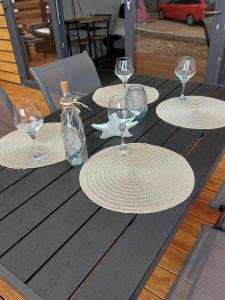 a table with four empty wine glasses and a bottle at Mobile Home Marta in Senj +11 photos