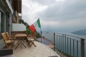 uma varanda com uma mesa e cadeiras e uma bandeira em Appartamento Vittoria em Parzanica