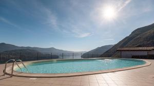 a swimming pool on a patio with mountains in the background at Appartamento Vittoria in Parzanica