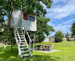 a tree house with a ladder leading up to it at Chalet Sch-l-afbock in Markranstädt