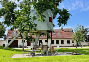 a group of chairs and a tree with a house at Chalet Sch-l-afbock in Markranstädt +27 photos