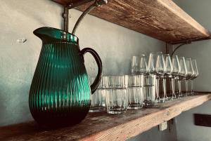 a green vase sitting on a shelf with glasses at Chalet Sch-l-afbock in Markranstädt