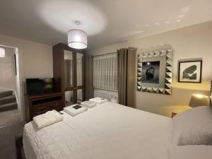sypialnia z dużym białym łóżkiem i telewizorem w obiekcie MODERN 4 BEDROOM HOUSE WITH GARDEN & PARKING w mieście Swanscombe