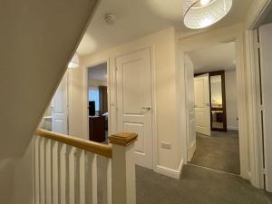 a hallway with a stairway with a stair case at MODERN 4 BEDROOM HOUSE WITH GARDEN & PARKING in Swanscombe