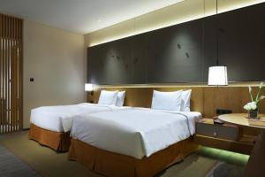 Habitación de hotel con 2 camas grandes y mesa en Crowne Plaza Nanchang Wanli, an IHG Hotel, en Nanchang