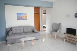 a living room with a couch and a table and chairs at Elegant Maisonettes Elena in Nea Potidaea