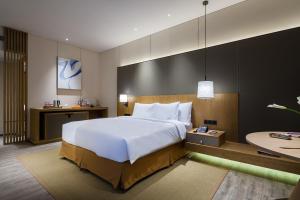 Habitación grande con cama grande y escritorio. en Crowne Plaza Nanchang Wanli, an IHG Hotel, en Nanchang
