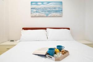 a bed with a tray of food and a book at Blue by PortofinoHomes in Portofino