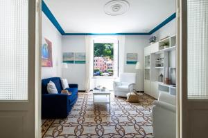 a living room with a blue couch and two chairs at Blue by PortofinoHomes in Portofino
