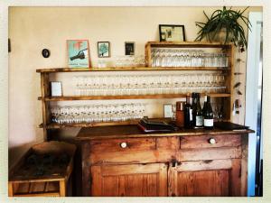un bar con muchas copas de vino en un estante en Mas Lluganas en Mosset