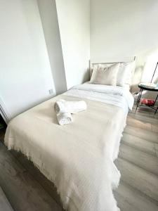 a white bed with towels on it in a room at Cosy apartment in town centre in Finedon