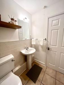 a bathroom with a white toilet and a sink at Cosy apartment in town centre in Finedon