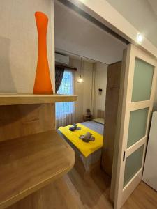 a small room with a bed and an orange vase at New apartment BARNABA close to Holiday Inn in Tbilisi City