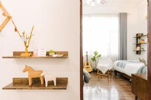 An Family Homestay في هانوي: غرفة مع سرير ورف مع حيوانات خشبية