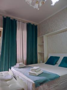 1 dormitorio con 2 camas, cortinas verdes y toallas en Vacanze romane, en Roma