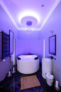 Habitación púrpura con baño con bañera grande. en Arts Apartments - Kraków Old Town, en Cracovia