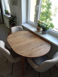 a wooden table and chairs in a room with a window at Rannarajooni holiday apartment in Pärnu