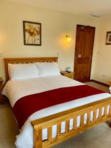 een slaapkamer met een groot bed en een rode deken bij Sunset House B&B in Penrith