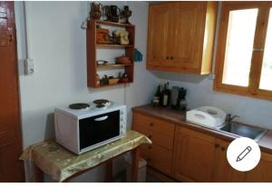 a kitchen with a microwave on top of a counter at Tree house nikiforos in Kissamos