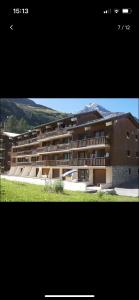 a large apartment building with a mountain in the background at Le Petit Chalet Addicted to Paradise in Tignes