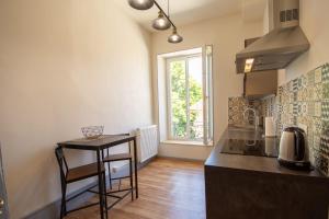 uma cozinha com um balcão, uma mesa e uma janela em Domaine des Granges Longes em Les Marches