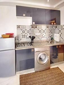 y cocina con fogones y lavadora. en appartement center de Guéliz avec piscine, en Marrakech
