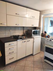 a kitchen with white cabinets and a microwave at Pokoje u Natalii in Dziwnów