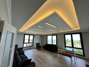 a living room with a large ceiling with windows at Sea View Villa in Trabzon