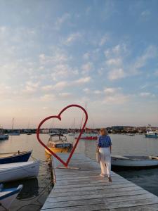 a woman standing on a dock with a heart on it at Apartmani B&B in Ližnjan