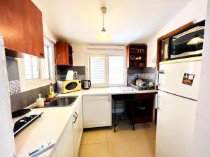a kitchen with a white refrigerator and a sink at КВАРТИРА ВОЗЛЕ МОРЯ! in Haifa