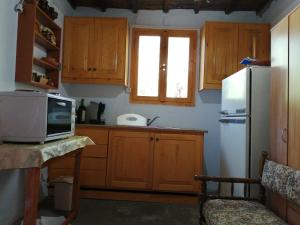 een keuken met houten kasten en een witte koelkast bij Tree house nikiforos in Kissamos