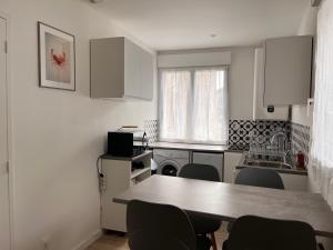 una cocina con mesa y sillas. en Studio récent, entièrement équipé, proche Chantiers et Airbus, en Saint-Nazaire 6 fotos más