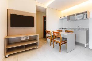 a living room with a table and chairs and a television at Salinas park resort in Salinópolis