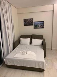 a bed with white sheets and pillows in a room at Salinas park resort in Salinópolis