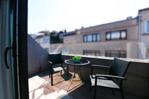 un balcón con 2 sillas y una mesa con una planta en Inncity Hotel Nisantasi en Estambul