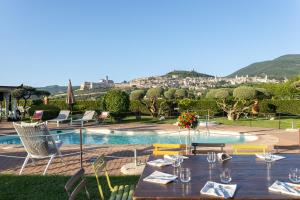 mesa de comedor con vistas a la piscina en UNICA Assisi agri-charming house, en Asís