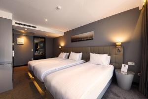 2 camas en una habitación de hotel con sábanas blancas en Inncity Hotel Nisantasi, en Estambul