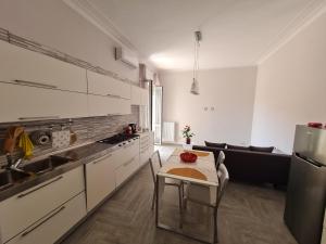 a kitchen with white cabinets and a table and a sink at Costa del Sole in Salerno