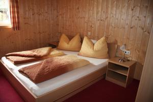 a bed with pillows on it in a room at Haus Lutea in Gaschurn