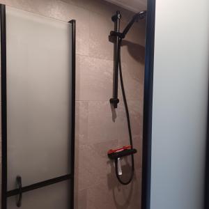een douche in een badkamer met een glazen deur bij B&B Keukja Cuijk in Cuijk
