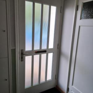 uma porta com uma janela num quarto em B&B Keukja Cuijk em Cuijk