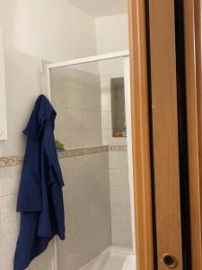 a bathroom with a shower with a blue jacket hanging at Casa di Filippo in Arcola