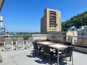 a patio with a table and chairs on a roof at Marina Bay Atami in Atami