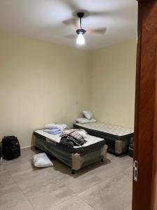 2 łóżka w pokoju z wentylatorem sufitowym w obiekcie Sitio chácara rancho bonanza w mieście Uberlândia