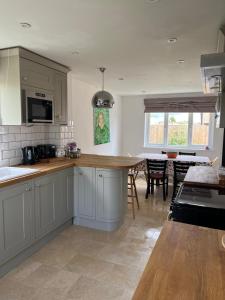 a kitchen with white cabinets and a dining room at Home in Buckland Brewer near Bideford in Bideford