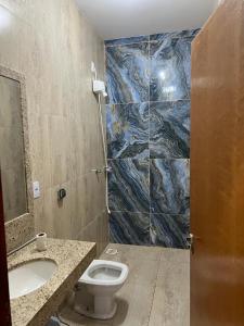 W łazience znajduje się toaleta, umywalka i lustro. w obiekcie Sitio chácara rancho bonanza w mieście Uberlândia