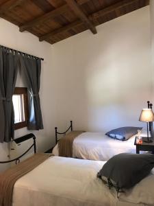 a bedroom with two beds and a window at Agriturismo Fattoria Antica Forconia in LʼAquila